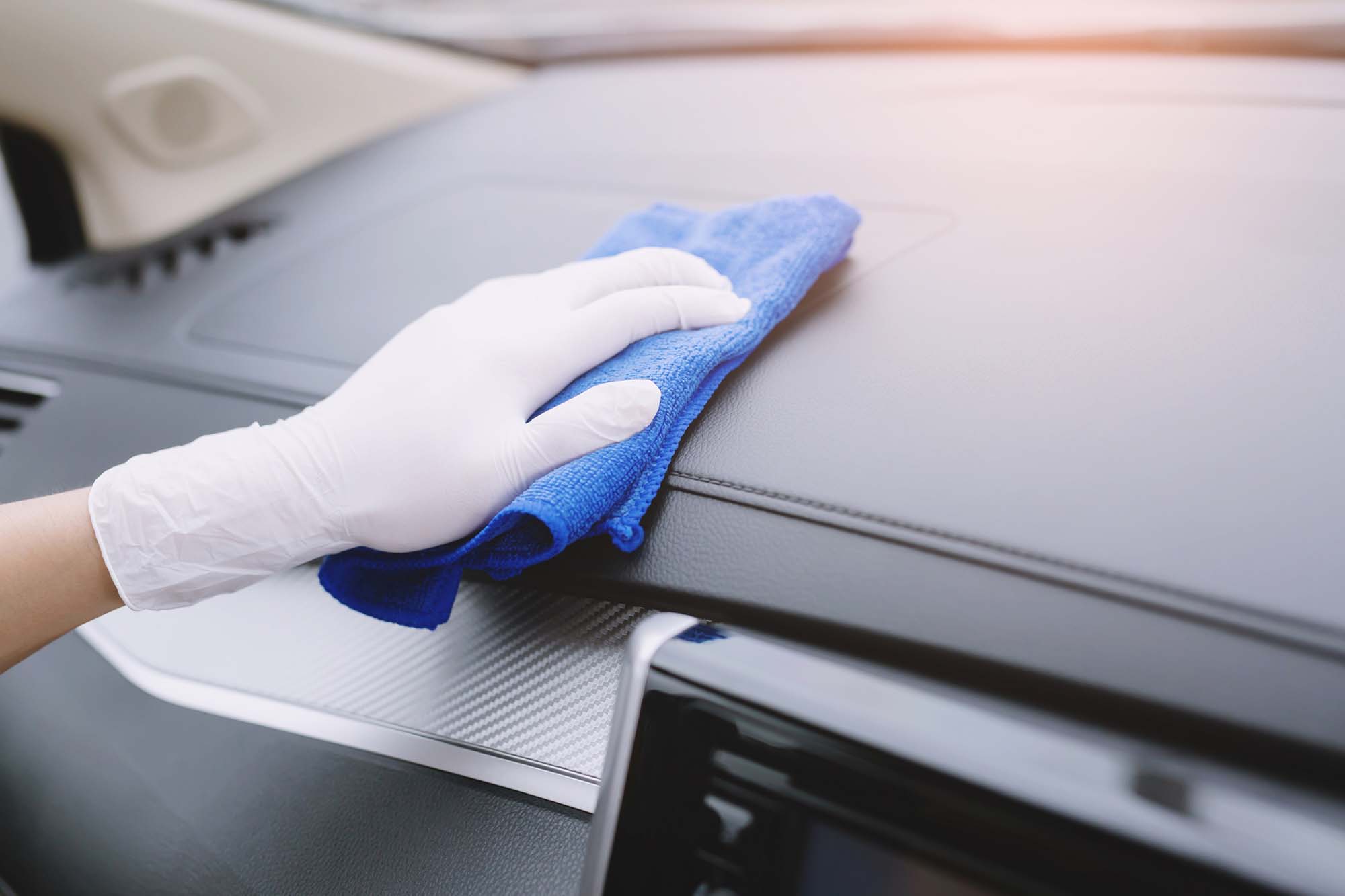 Worker man wear gloves cleaning car interior console with microfiber cloth, detailing, car wash service concept. copy space.