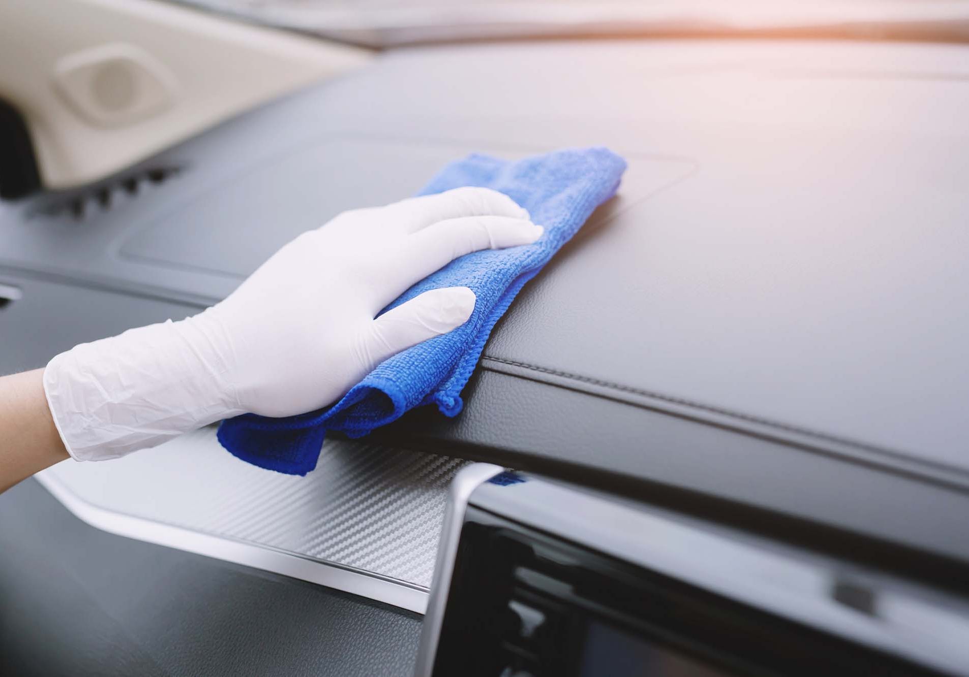 Worker man wear gloves cleaning car interior console with microfiber cloth, detailing, car wash service concept. copy space.